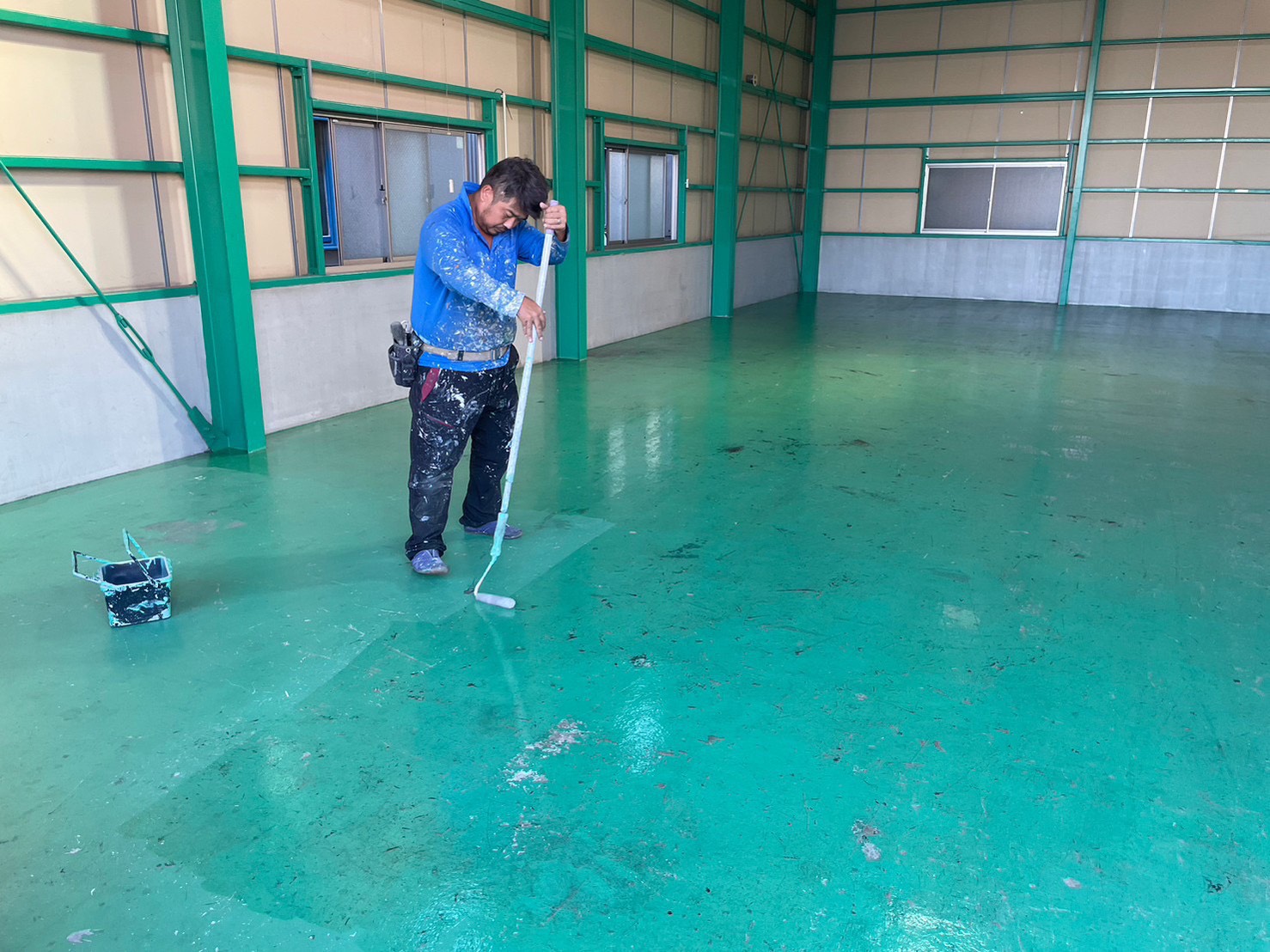 名古屋市守山区の倉庫床塗装。ボウジンテックスワイドシーラーで床を塗っている作業写真