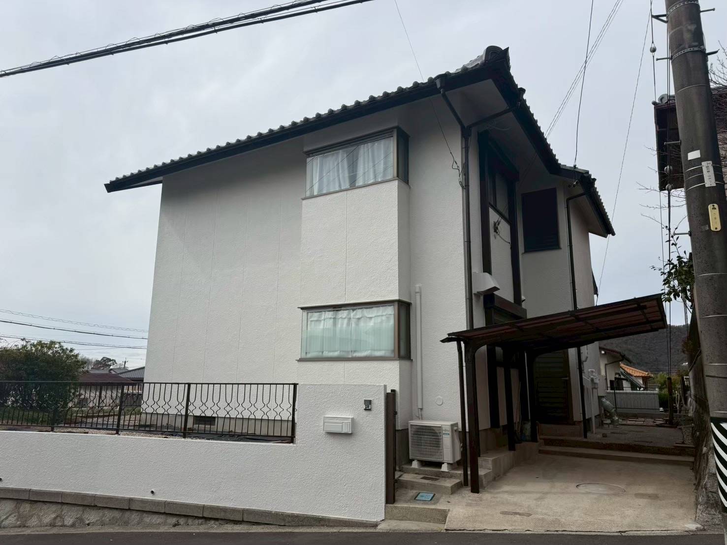 各務原市の一戸建て外壁塗装完了後の横側アフター写真。ガレージ側から見た真っ白で清潔感のある和モダンな外観。