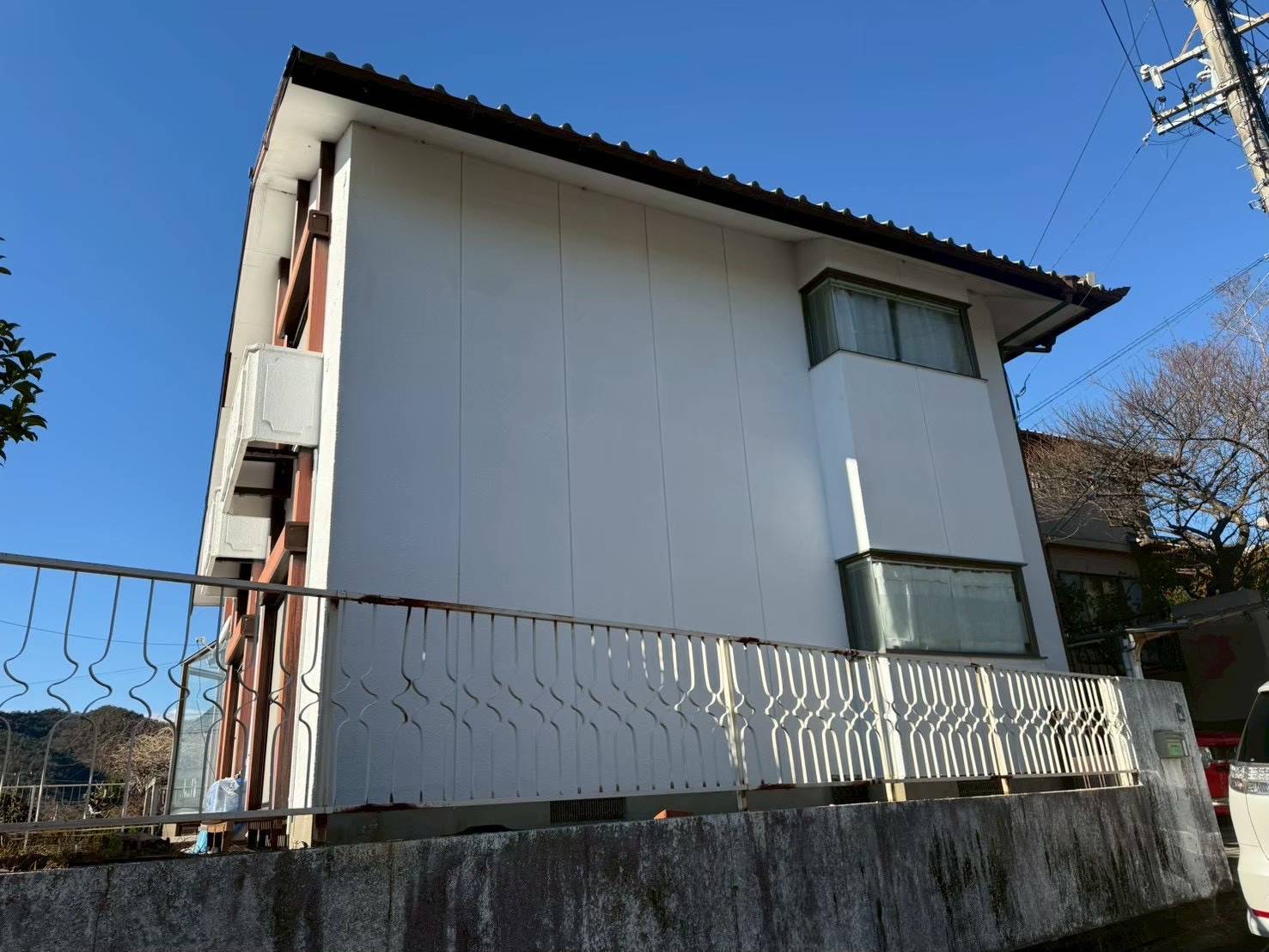 各務原市の一戸建て外壁塗装前の横側ビフォー写真。経年による外壁の雨筋汚れやくすみが見られるガレージ側からの外観。