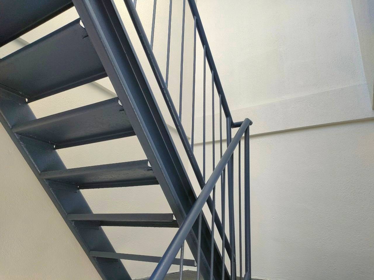 岐阜市のマンション修繕における屋外鉄骨階段の塗装完了後のアフター写真。クリーンマイルドシリコン（75-30D）で美しく塗り替えられた階段と手すり。