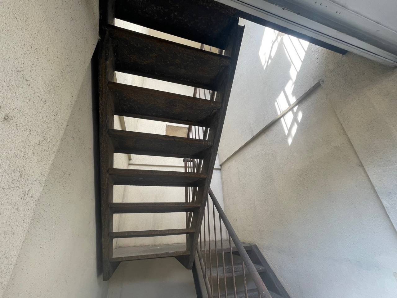 岐阜市のマンション修繕における屋外鉄骨階段塗装前の施工前写真。階段裏やステップ全面に激しい茶サビが発生している現状。