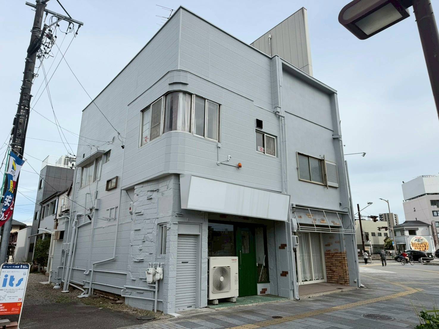 名古屋市西区の店舗塗装完了後の完成写真。水性セラミシリコンのN-70グレーで美しく塗り替えた2階建て店舗ビル。