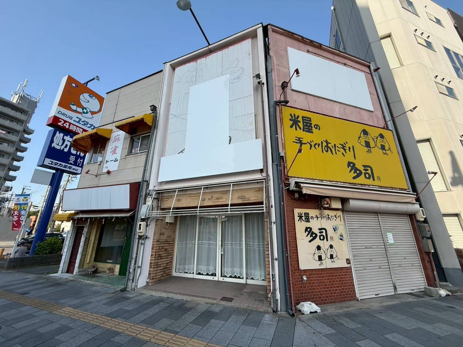 名古屋市西区の店舗塗装前の施工前写真。古い麻雀看板や色あせたテントが残る塗り替え前のおにぎり店側外観。