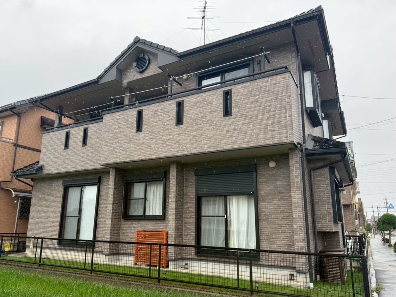 清須市の外壁塗装前における住宅の施工前（Before）写真。塗り替え前のブラウン系レンガ調サイディング外壁の現状。
